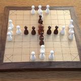 Compact 25-piece Hnefatafl game set up for tablut